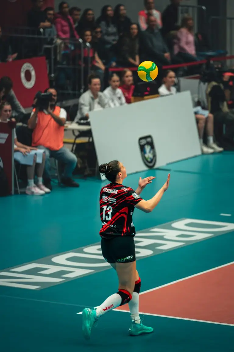 DSC Dresden Volleyballspielerin Rosemann mit Trikotnummer 13 beim Aufschlag auf dem türkisfarbenen Hallenboden der Dresdner Heimspielstätte