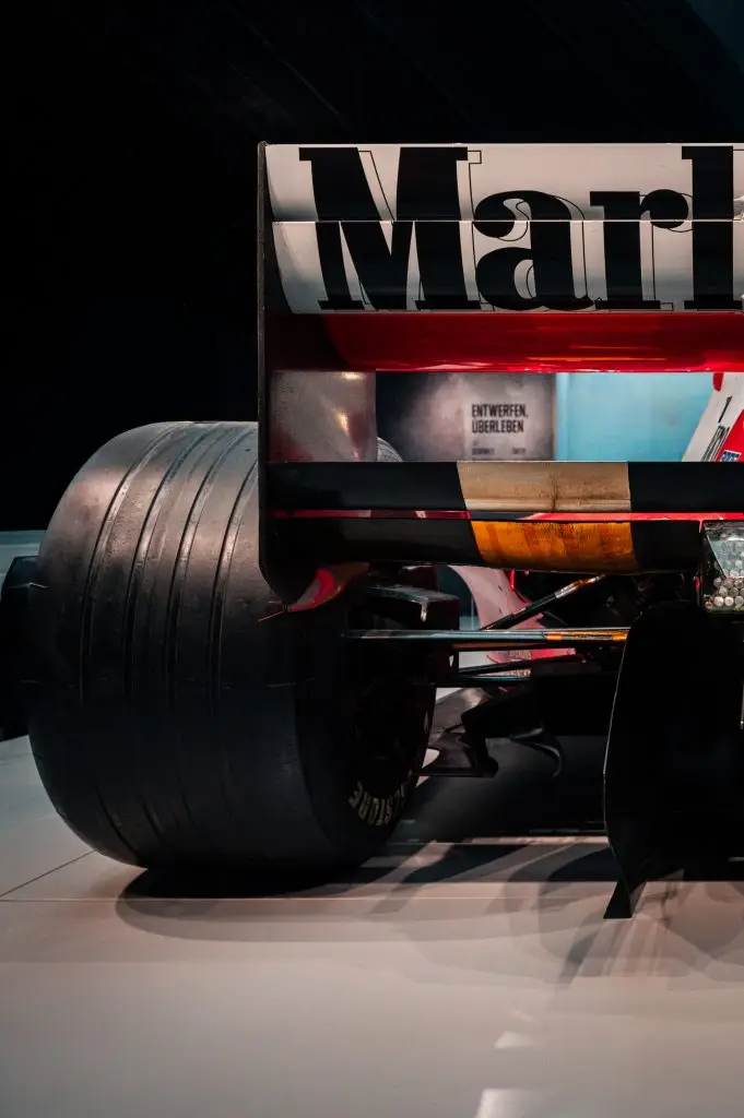 Detailaufnahme des Hecks eines Michael Schumacher Ferrari Formel-1-Rennwagens mit Marlboro-Heckspoiler, Bridgestone-Slick-Reifen und freiliegender Hinterradaufhängung in einer Museumsausstellung